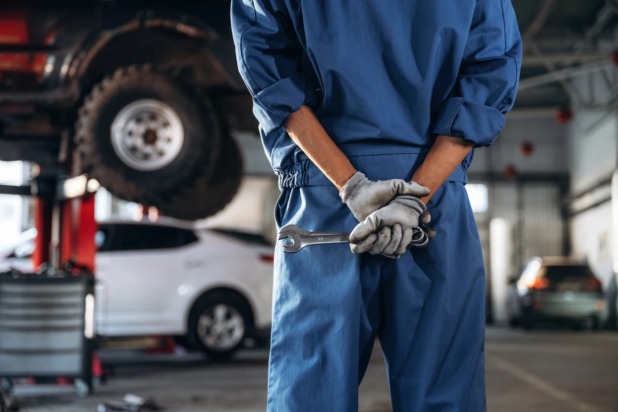 Exposition intérieure d'une voiture de collection rouge dans un showroom aux rideaux sombres, éclairage professionnel mettant en valeur le véhicule sur parquet bois